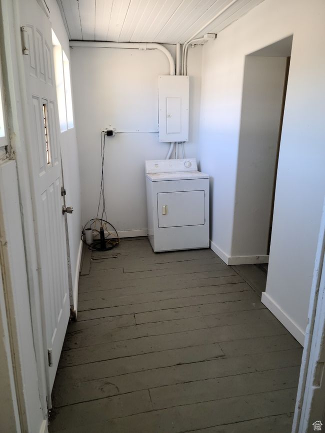 Washroom with washer / clothes dryer, electric panel, wood-type flooring, and baseboards | Image 37