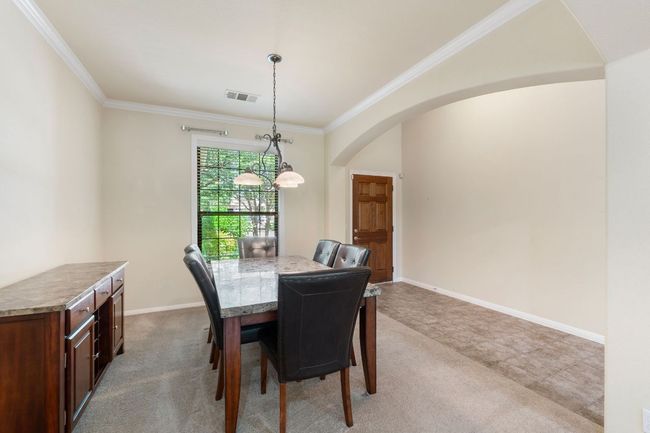 Dining space featuring arched walkways, crown molding, and carpet floors | Image 5