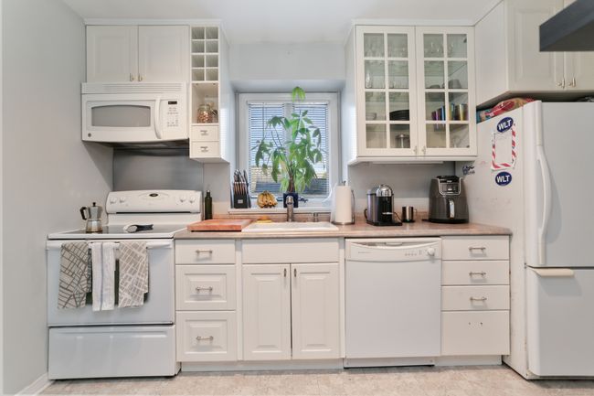 White cabinets throughout, one set with glass doors to display your favorite dishes. The kitchen has a garbage disposal, replaced in 2020. | Image 10