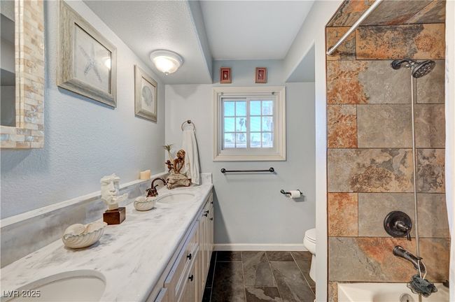 Full bath with double vanity, toilet, bathtub / shower combination, and baseboards | Image 51