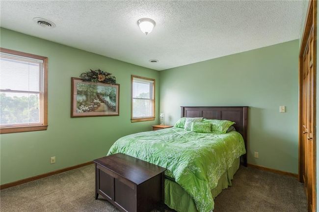 Carpeted bedroom with a textured ceiling, visible vents, and baseboards | Image 50