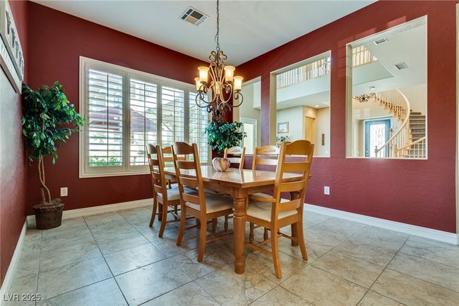 Tiled dining area with a notable chandelier, baseboards, and visible vents | Image 19