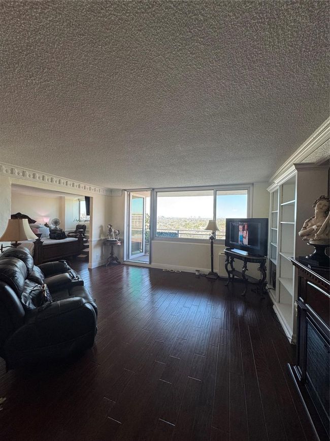 Living area with a textured ceiling and wood finished floors | Image 6