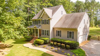 View of front facade with a garage, a front yard, and a porch | Image 2