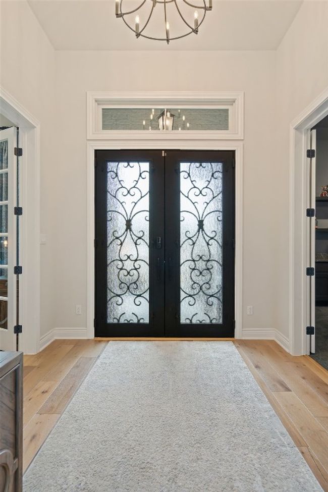 Foyer entrance with baseboards, french doors, wood-type flooring, and a notable chandelier | Image 6