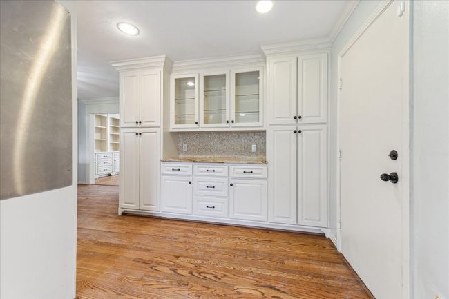 Lovely breakfast room with convenient built-in cabinet with granite counter, glass shelves, and ample storage. | Image 5