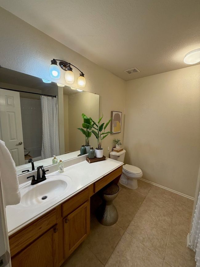 Bathroom featuring toilet, vanity, a shower with curtain, and tile patterned floors | Image 17