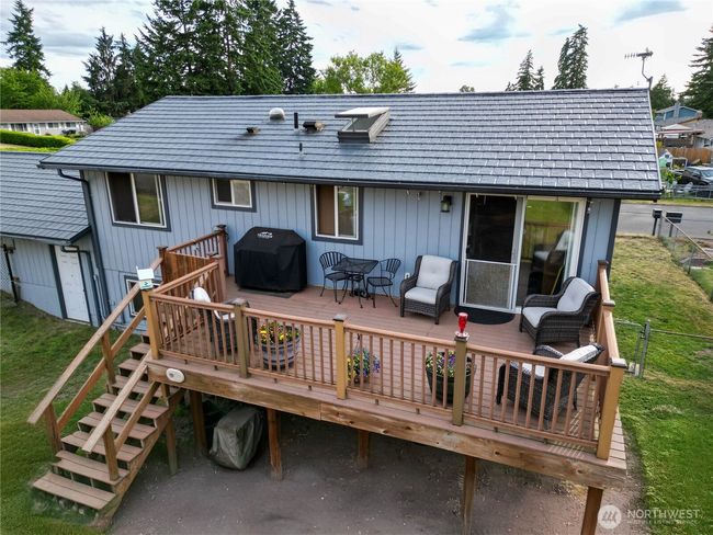 Spacious raised deck perfect for entertainment offers a relaxed, private outdoor living space with views of the surrounding neighborhood and mature trees in the distance. | Image 13