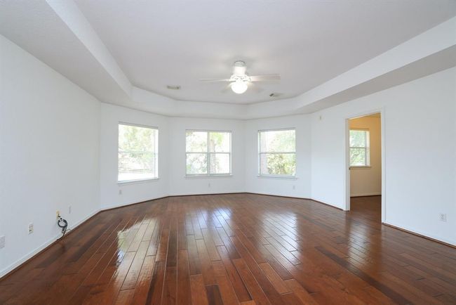 Bow bay window looks over the backyard pool area. | Image 25