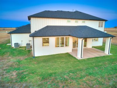 Back house at dusk featuring a patio, cooling unit, and a lawn | Image 3