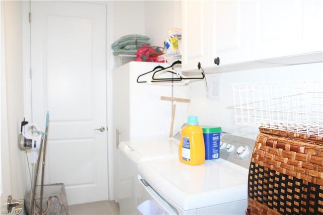 Clothes washing area featuring washer and dryer and cabinet space | Image 23