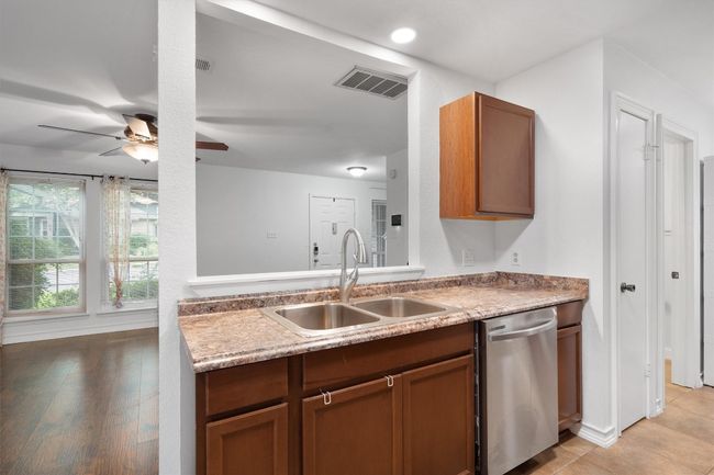Kitchen with dishwasher, a ceiling fan, brown cabinets, and light countertops | Image 16