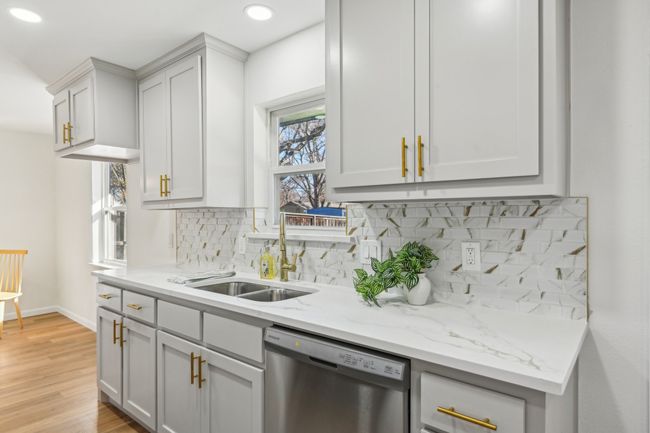 Kitchen with stainless steel dishwasher, a sink, decorative backsplash, baseboards, and recessed lighting | Image 10
