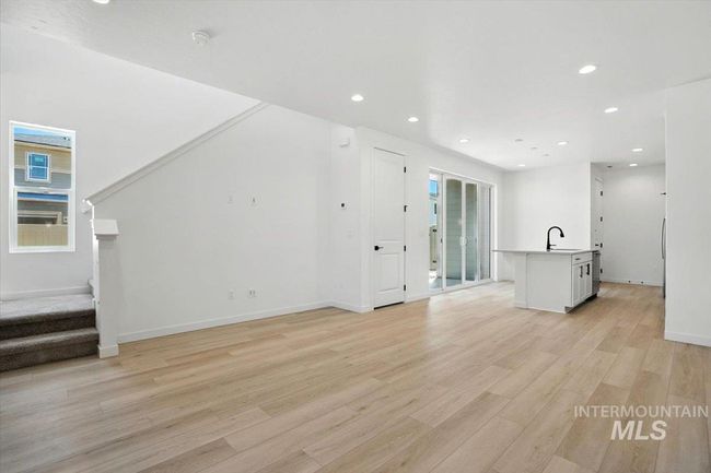 Unfurnished living room with light wood-type flooring, stairs, and recessed lighting | Image 5
