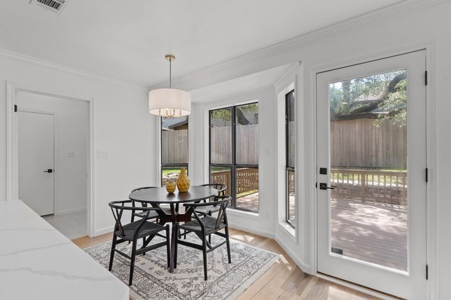 Dining space with plenty of natural light, ornamental molding, light wood-type flooring, and baseboards | Image 7