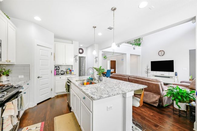 Kitchen with appliances with stainless steel finishes, open floor plan, dark wood-style flooring, tasteful backsplash, and recessed lighting | Image 11