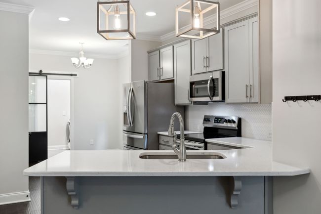 Beautiful cabinets, counters and lighting. All stainless steel appliances and refrigerator to remain. | Image 6