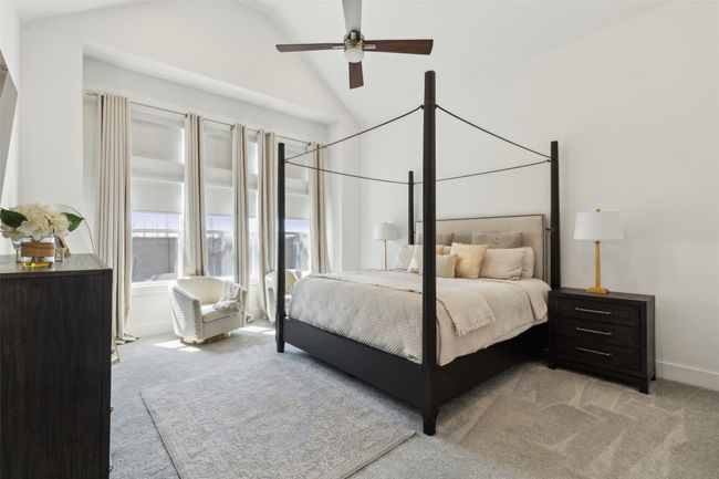 Bedroom with light colored carpet, lofted ceiling, a ceiling fan, and baseboards | Image 15