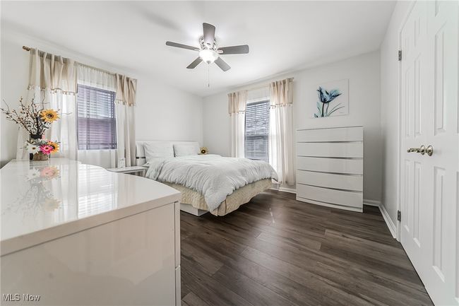 Bedroom with multiple windows, a ceiling fan, baseboards, and dark wood-style flooring | Image 20