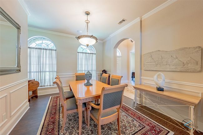 Dining area with dark wood-type flooring and ornamental molding | Image 24