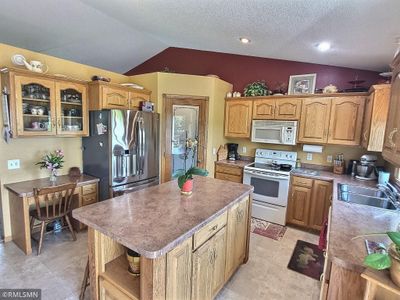 The Kitchen has tons of cupboard space, large center island, built in desk and huge pantry. | Image 3