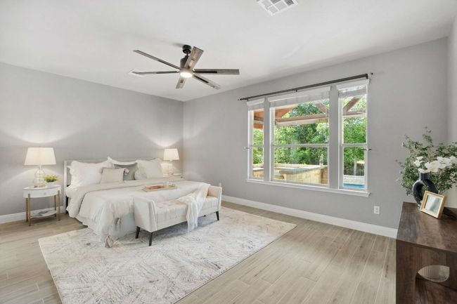 The oversized primary bedroom is on the main floor and overlooks the sparkling pool. | Image 18