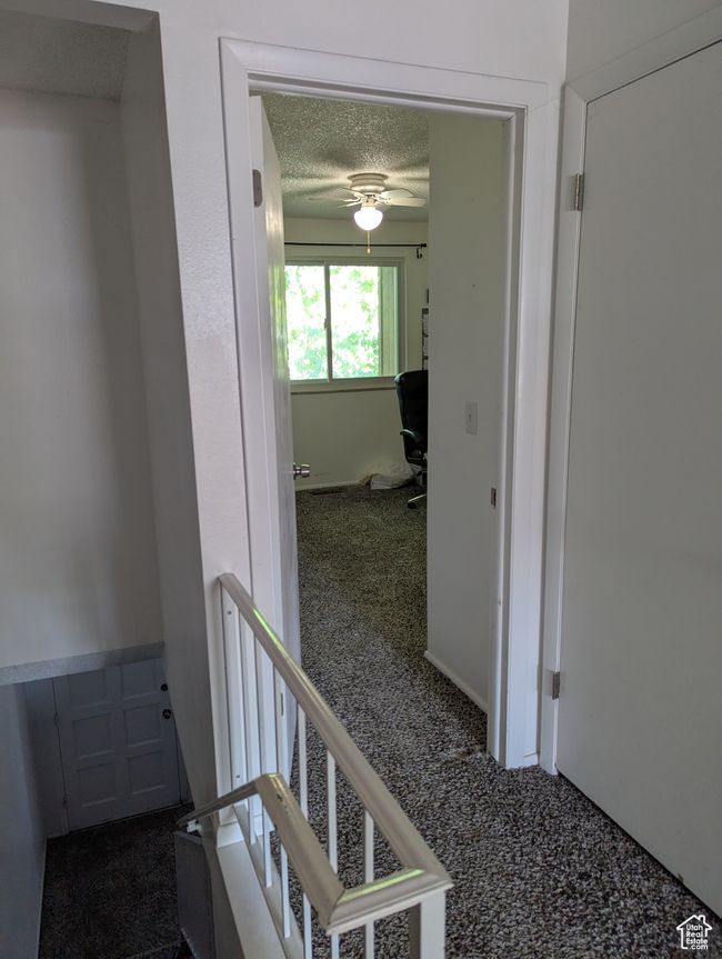 Hall featuring carpet, a textured ceiling, and an upstairs landing | Image 12