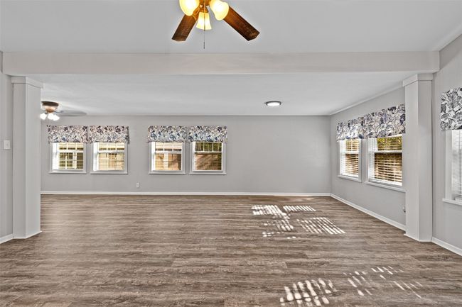 Unfurnished living room featuring plenty of natural light, wood finished floors, and ceiling fan | Image 14
