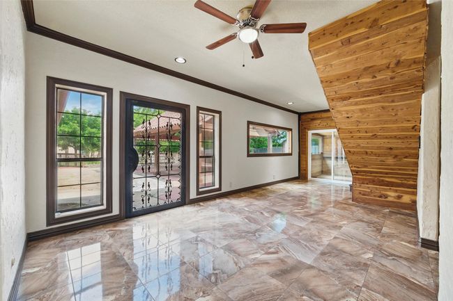 Unfurnished room featuring wooden walls, ornamental molding, marble finish flooring, ceiling fan, and recessed lighting | Image 20