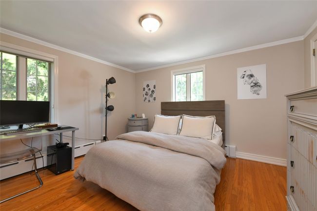 Bedroom with multiple windows, light wood-type flooring, baseboards, and crown molding | Image 17