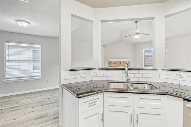 The kitchen includes a practical double-basin undermount sink positioned beneath the breakfast bar, with a convenient dishwasher located just to the right. | Image 13
