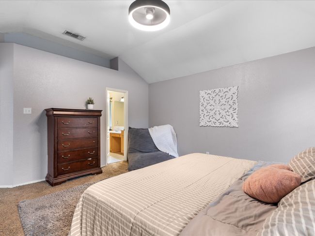 Bedroom featuring lofted ceiling, light colored carpet, and connected bathroom | Image 17