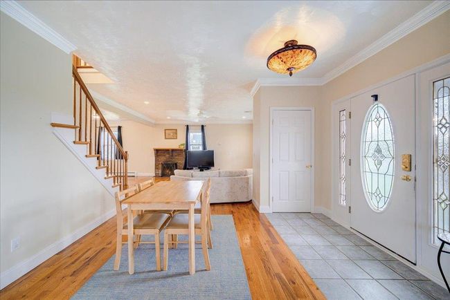 Entrance foyer with stairway, baseboards, ornamental molding, and wood finished floors | Image 7