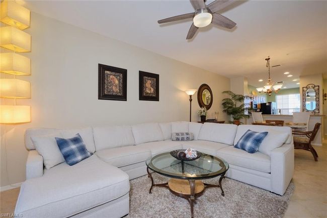 Tiled living room featuring ceiling fan with notable chandelier | Image 29