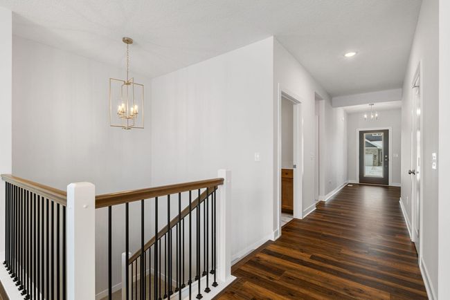 The impressive entryway features a grand staircase as its centerpiece, exuding timeless elegance. With soaring ceilings and an open design, it creates a warm and welcoming first impression that sets the stage for the rest of the home. | Image 5