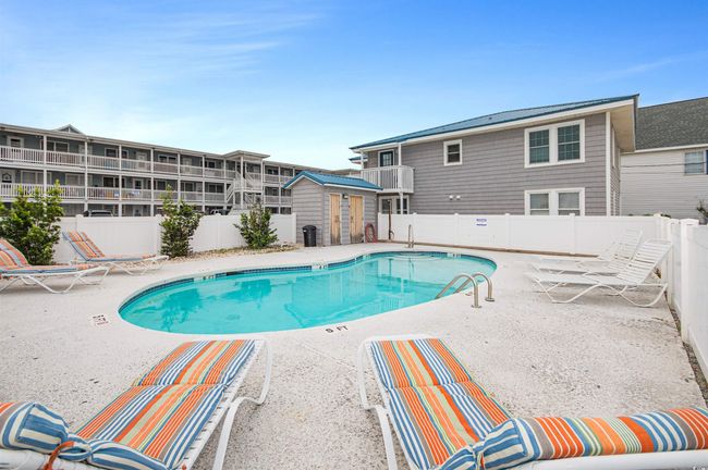 Community pool with a patio, a storage shed, and a fenced backyard | Image 5