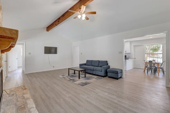 Living room featuring light wood-style floors, a ceiling fan, and baseboards | Image 4