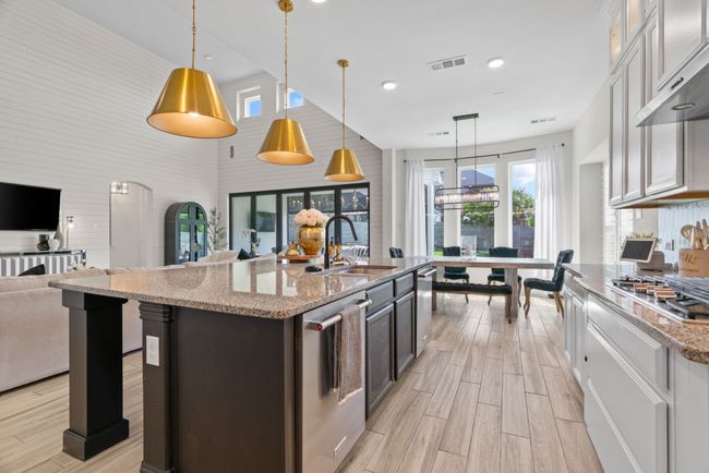 Kitchen featuring stainless steel appliances, a sink, open floor plan, light wood-style floors, and a towering ceiling | Image 11