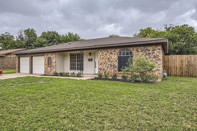 Ranch-style house with a front yard and a garage | Image 3