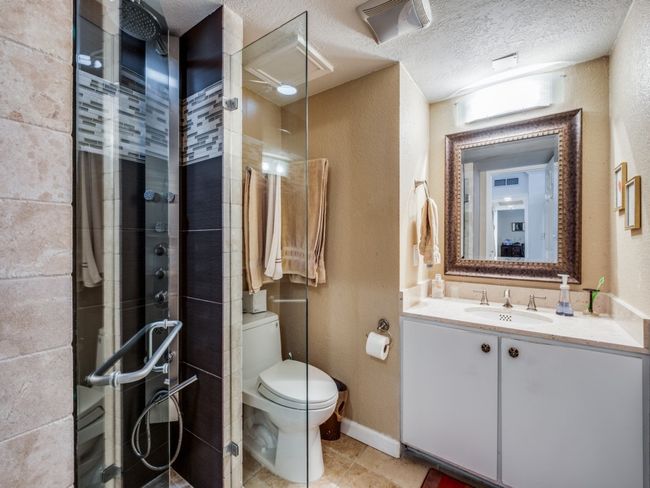 The Split Primary Bed. #2 with dark hardwood / wood-style flooring, updated ceiling fan, ensuite bath, walk-in closet, plantation shutters and ornamental molding! | Image 18