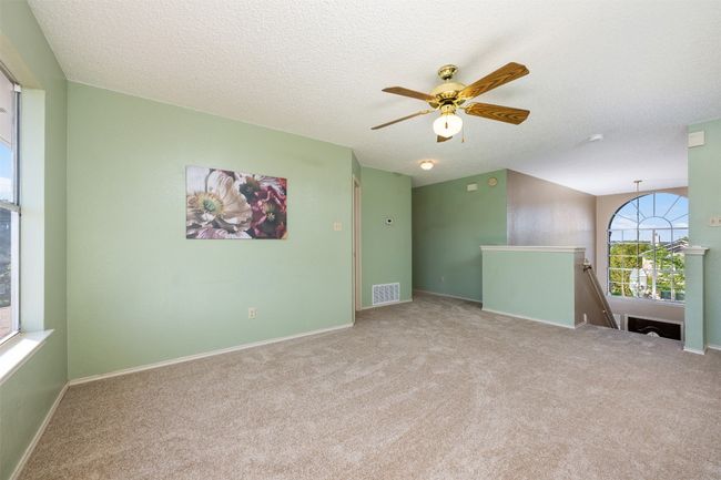 Carpeted empty room with visible vents, baseboards, a ceiling fan, and a textured ceiling | Image 18