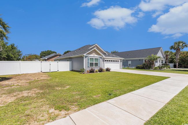 Ranch-style house featuring a gate, a garage, concrete driveway, and a shingled roof | Image 27