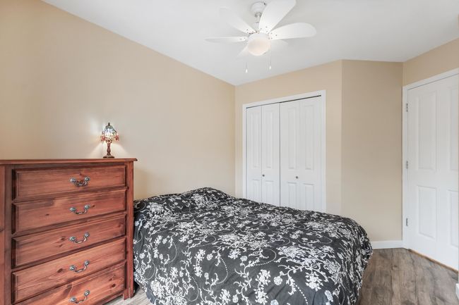 Bedroom with ceiling fan, a closet, baseboards, and wood finished floors | Image 23