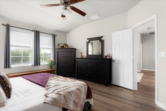 Bedroom with vaulted ceiling, wood finished floors, baseboards, and a ceiling fan | Image 14