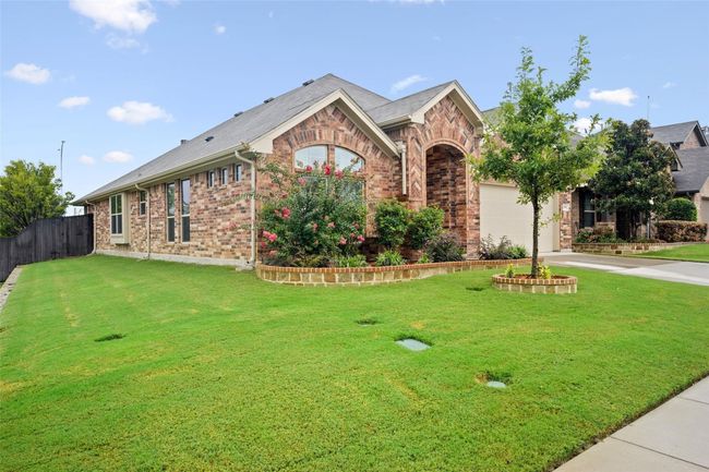 View of front of home with brick siding, driveway, and an attached garage | Image 22