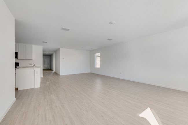Unfurnished living room featuring light wood-style floors and baseboards | Image 9