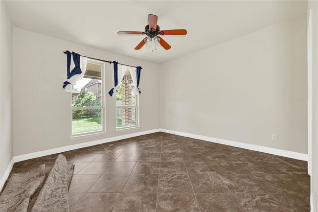 A bright first-floor bedroom features soft neutral tones and tall windows—complete with direct access to a private full bath. | Image 19