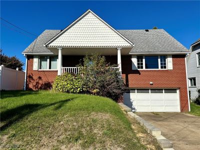 Front view of home featuring a front porch, yard and a garage | Image 1