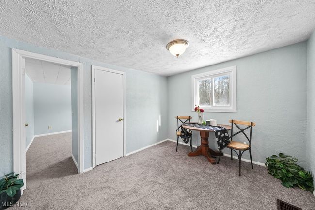 Dining room with textured ceiling and carpet flooring | Image 4