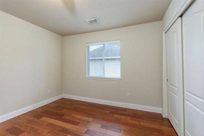 Unfurnished bedroom featuring wood finished floors, baseboards, and a closet | Image 24